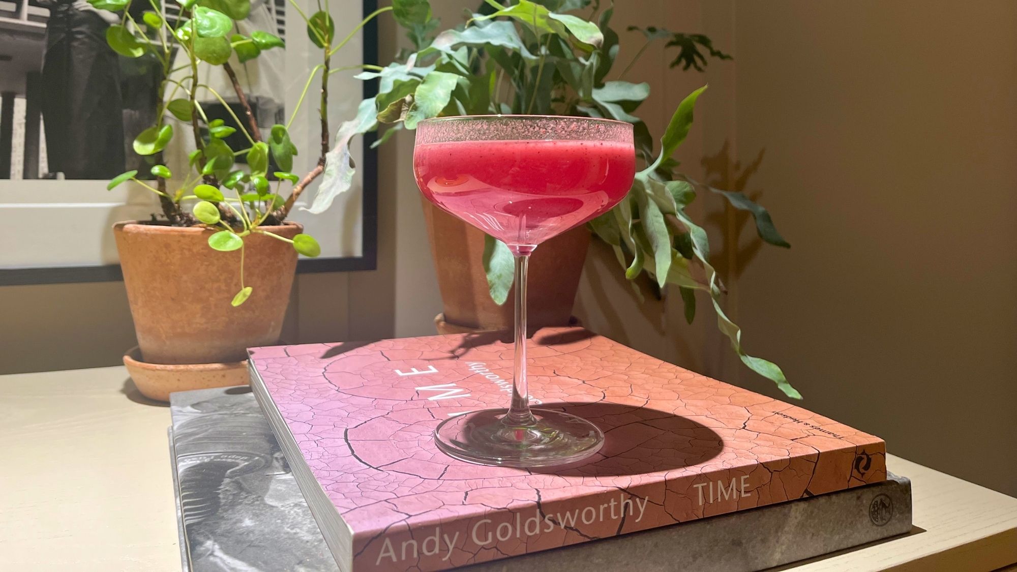 newroad 30 supplement in a goblet glass resting on top of two coffee table books