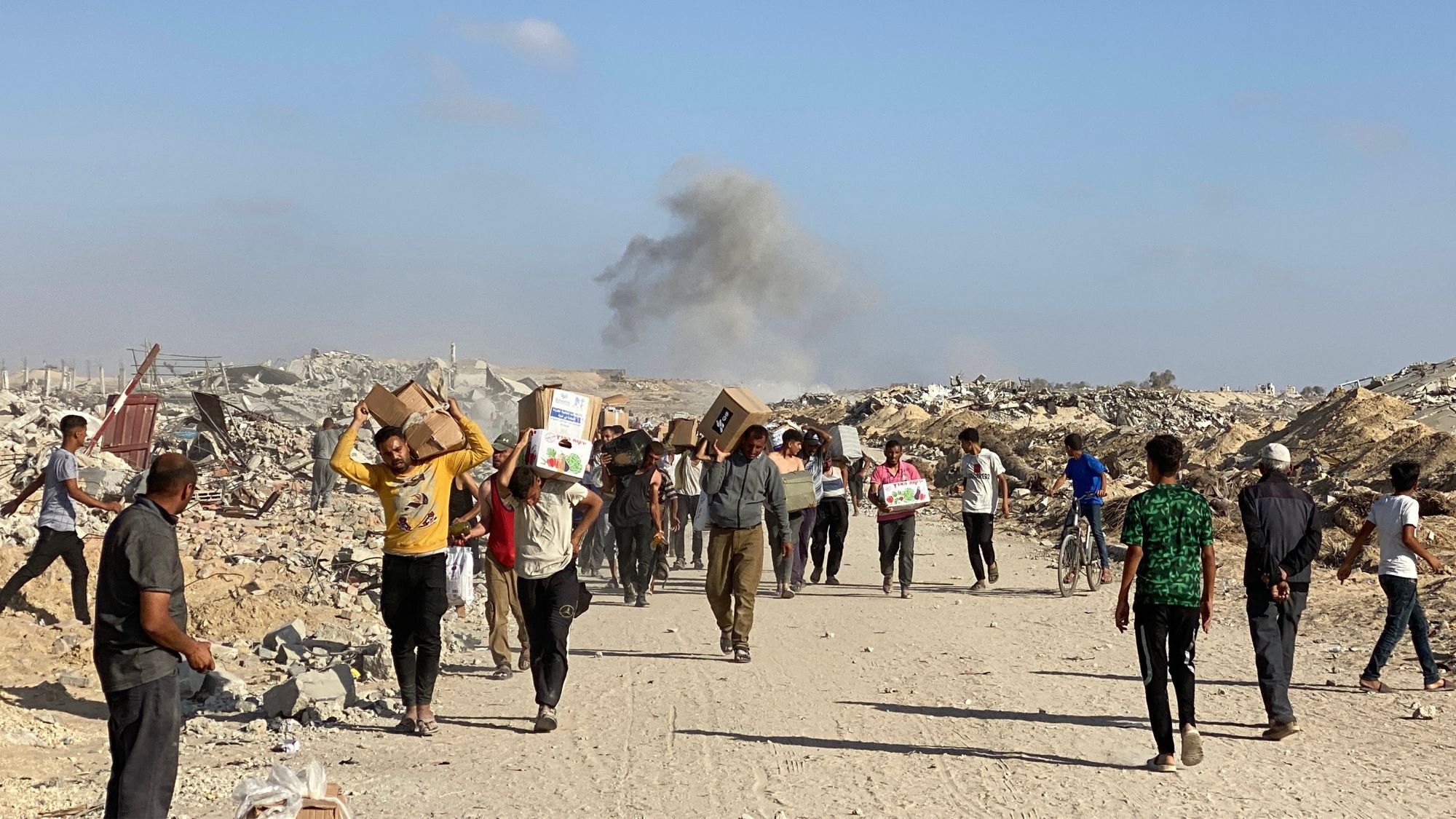 Displaced Palestinians receive food packages from a US-backed foundation pledging to distribute humanitarian aid in western Rafah in the southern Gaza Strip 