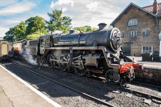 A steam train waiting at a station