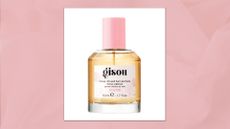 A bottle of the Honey Infused Gisou Wild Rose hair perfume, pictured against a textured pink template