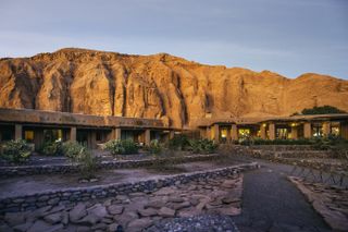 Two buildings at Nayara Alto Atacama in Chile with a giant rocky mountain behind them