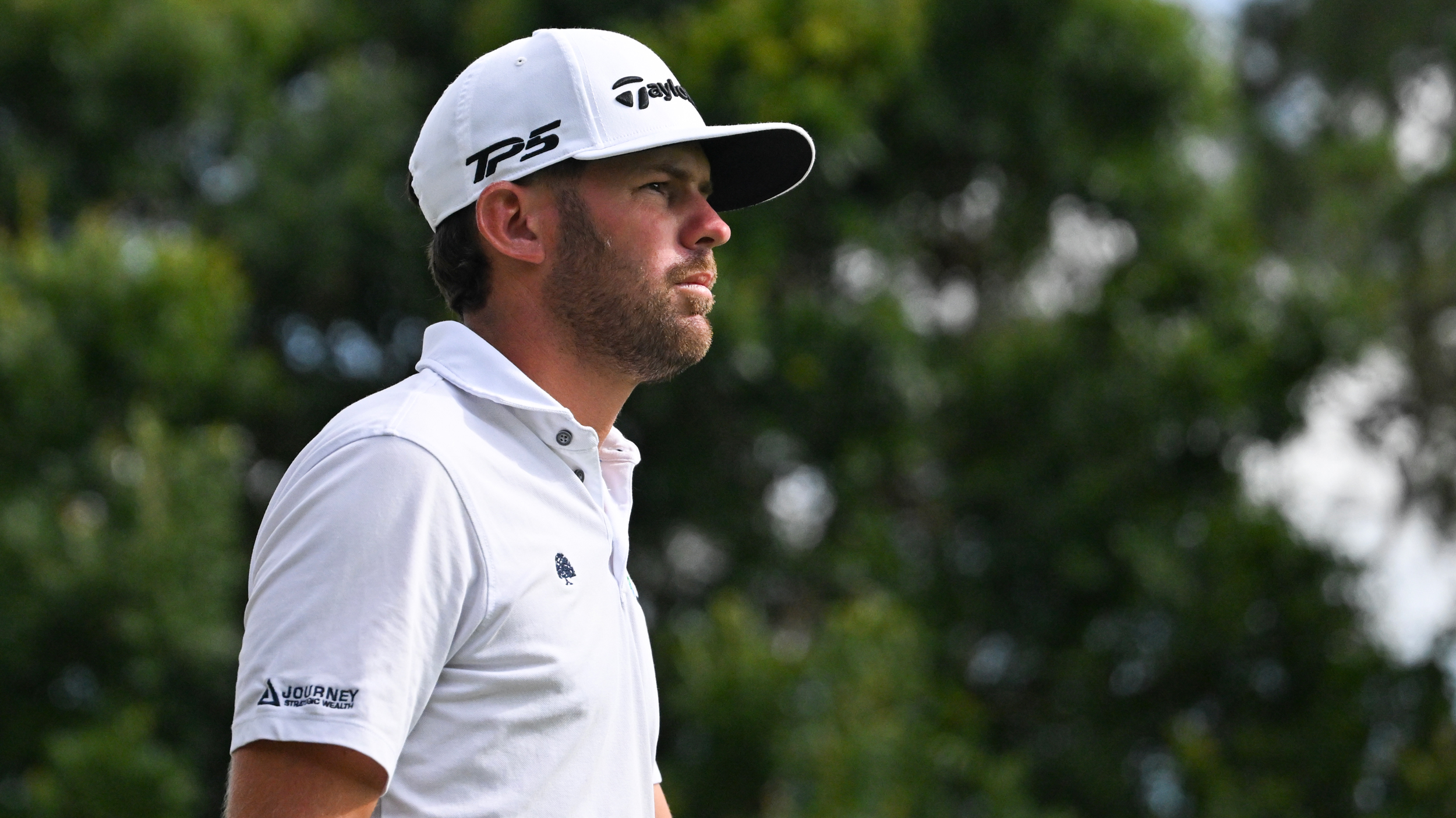 Tyler Collet wearing a white polo and white cap