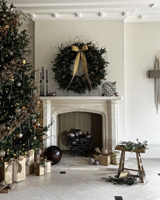 a fireplace decorated with a wreath and gold ornaments