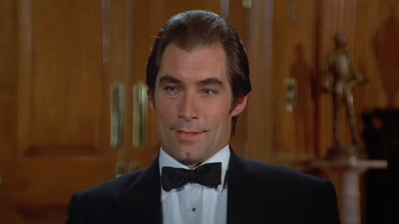 Timothy Dalton sits talking in a wood paneled office in License to Kill.