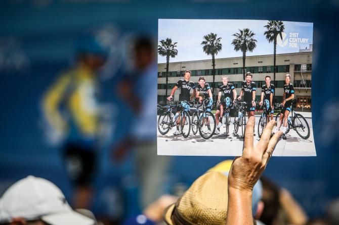 A fan holds up a Team Sky poster as Bradley Wiggins is interviewed on stage