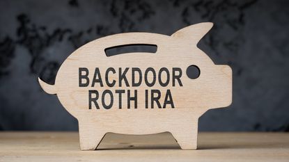 A wooden cutout of a piggy bank displays the words backdoor Roth IRA.