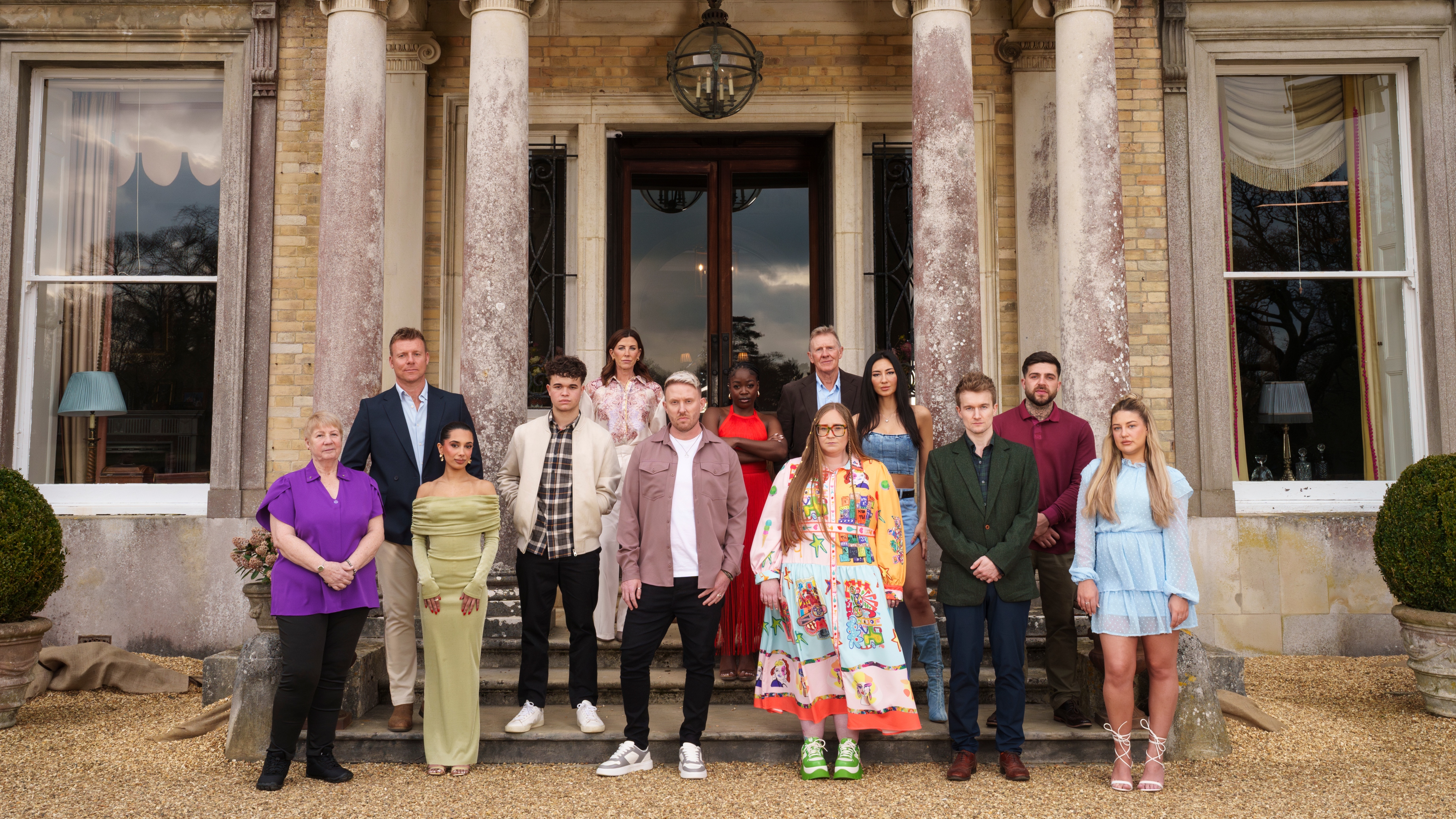 The cast of The Inheritance stood in front of the doors of the stately home where the game show was filmed.