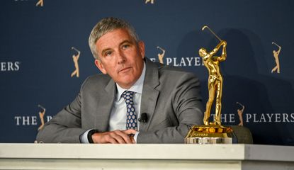 Monahan answers questions in a press conference next to the Players Championship trophy, Jay Monahan's Net Worth
