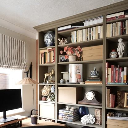 brown bookcase filled with books and ornaments in a home office