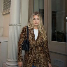 A woman wearing a leopard print coat with shiny, long, blonde hair