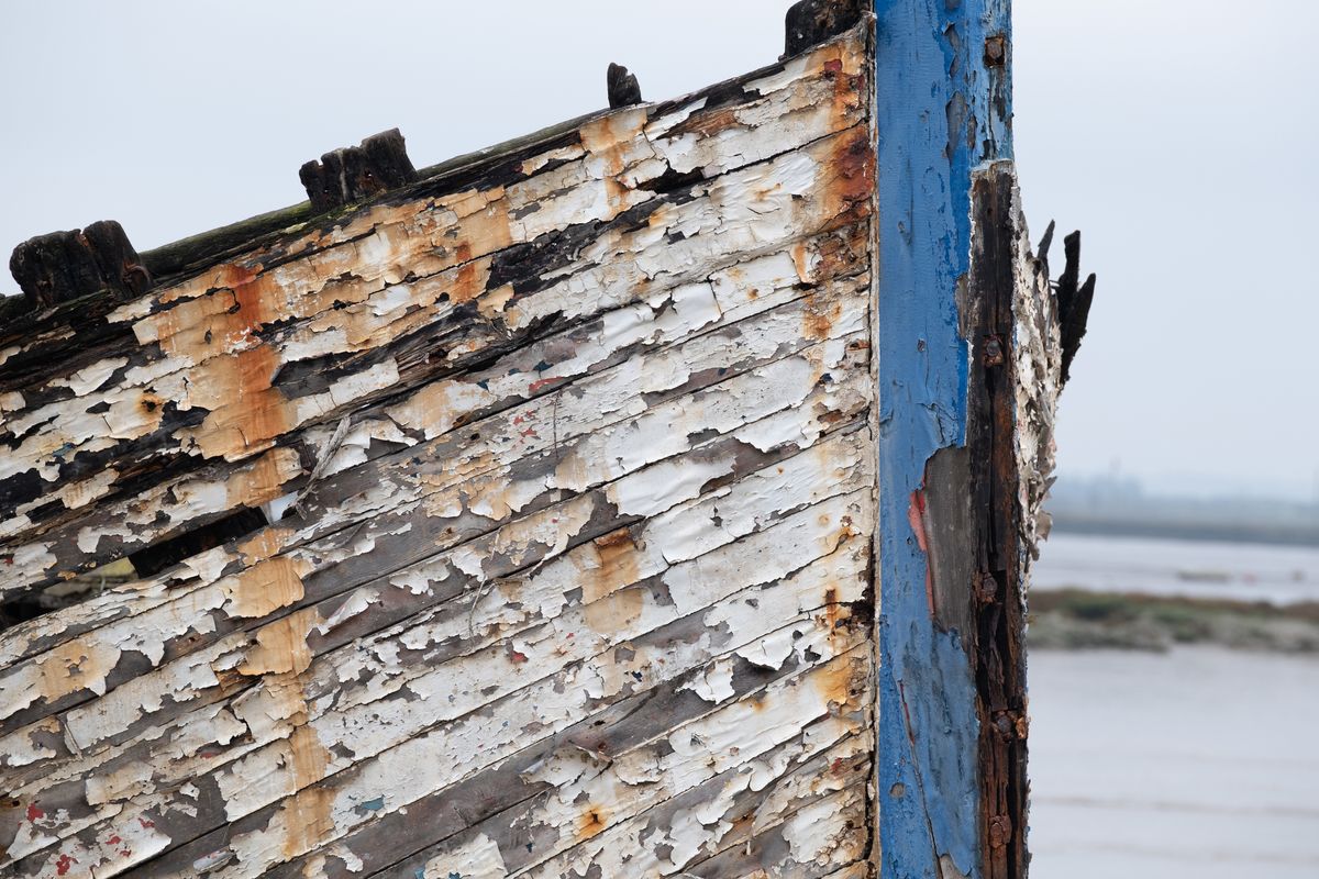 Paint peeling from the side of a wrecked boat