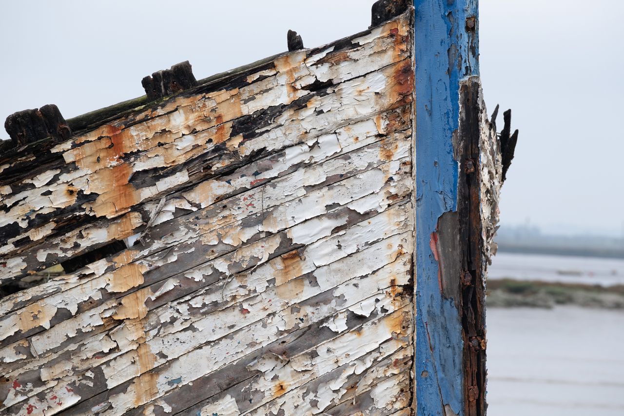 Paint peeling from the side of a wrecked boat