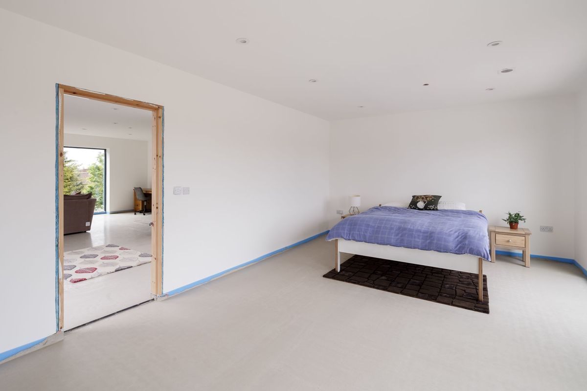 The bedroom has an en suite bathroom on the third floor and white interior walls and carpet