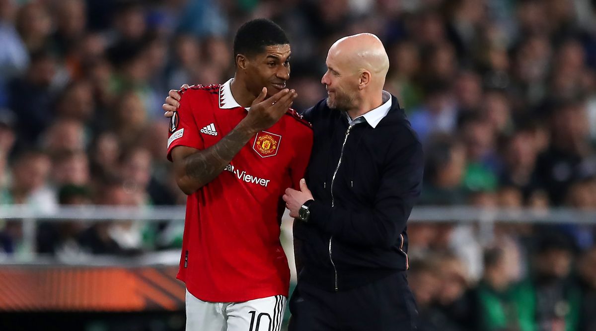 Manchester United manager Erik ten Hag speaks with player Marcus Rashford during the UEFA Europa League round of 16 second leg match between Real Betis and Manchester United at the Estadio Benito Villamarin on March 16, 2023 in Seville, Spain.