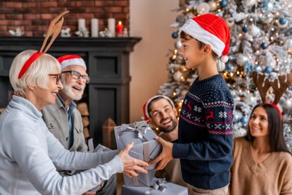 A family exchanging gifts in front of a Christmas tree