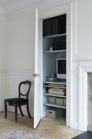 Hidden workstation in a cupboard with shelving