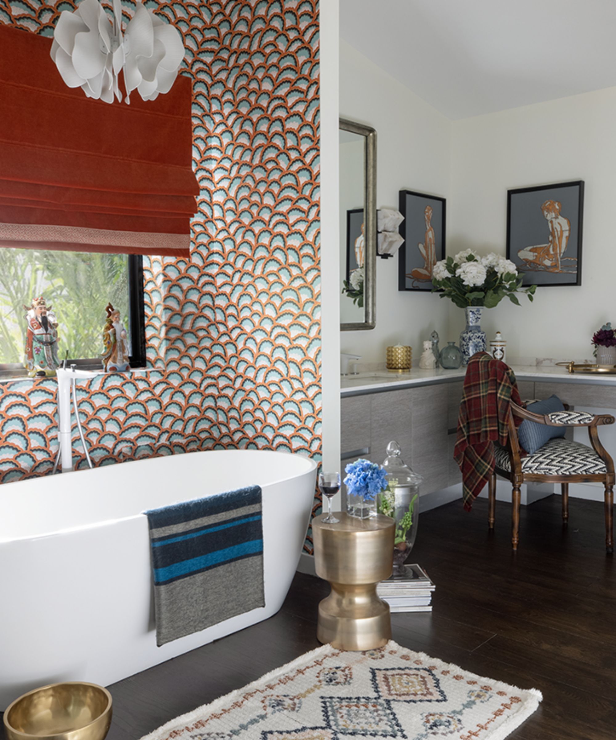 A maximalist bathroom with 70s-inspired wallpaper, a freestanding tub, and a vanity corner