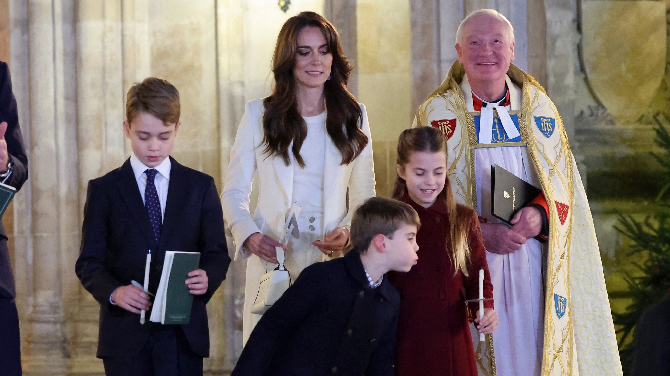 Princess Charlotte of Wales has her candle blown out by Prince Louis of Wales at the "Together At Christmas" Carol Service" at Westminster Abbey in London on December 8, 2023