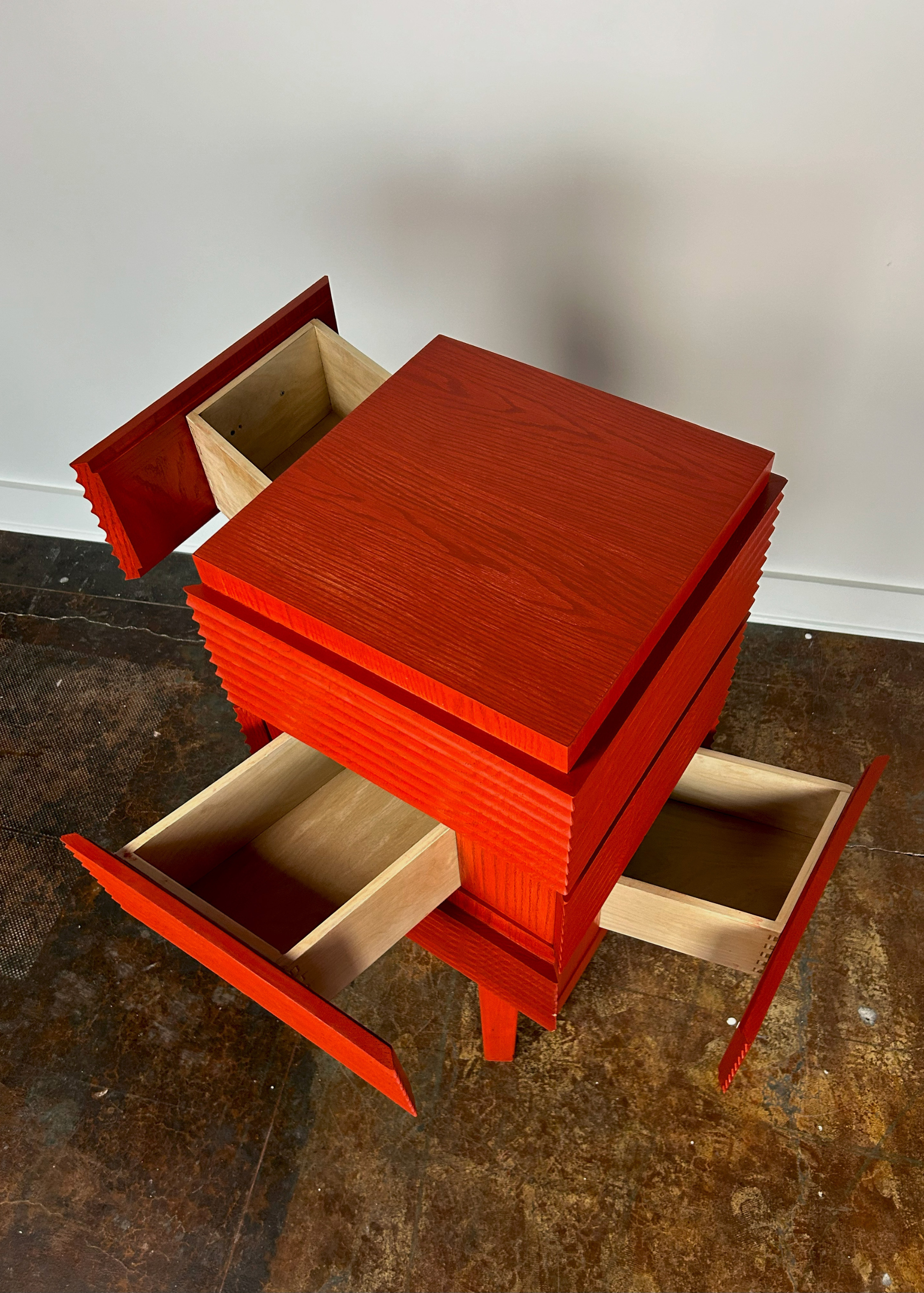 An orange ridged table with drawers pulled out