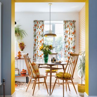 through dining room with retro dining table and chairs and yellow painted walls