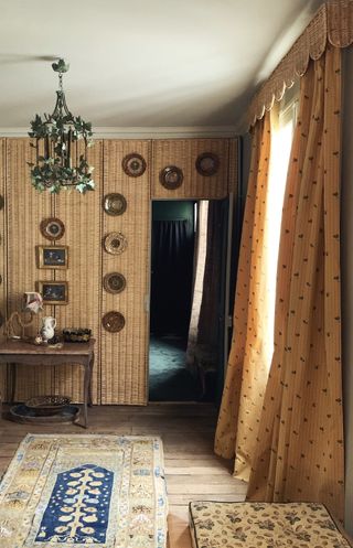 traditional interior with yellow curtains, a rattan scalloped pelmet and bamboo wall covering