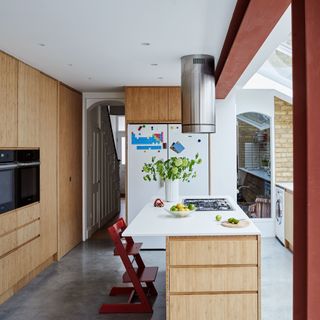 neutral wooden kitchen with kitchen island and Tripp Trapp high chair