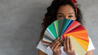 A woman holding up a color palette