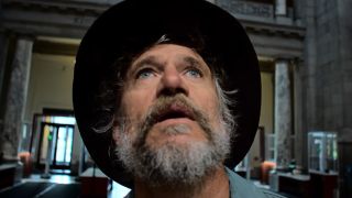 Steve Boyes looking at an elephant at the Smithsonian in Ghost Elephants