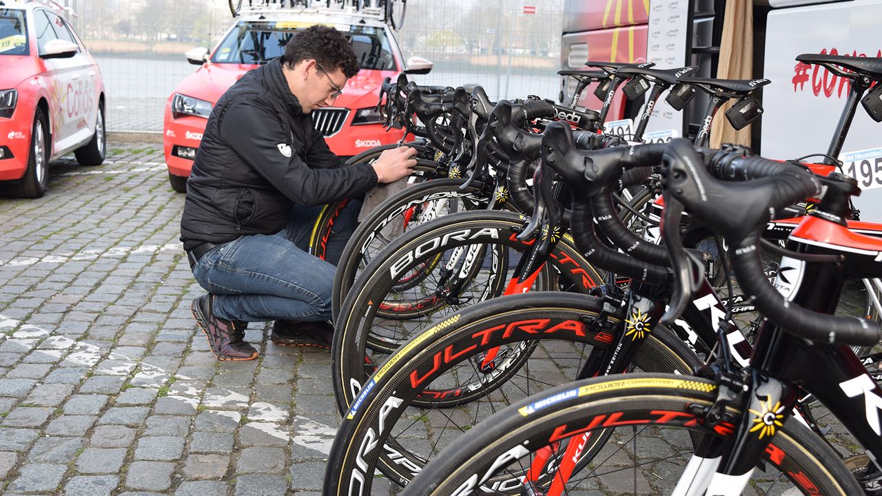 A Cofidis mechanic double checks tyres ahead of the race start
