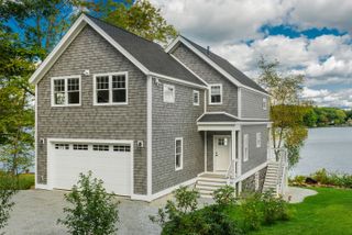 House overlooking pond with gray composite shingle