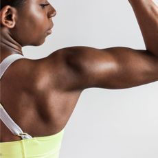 Morning workout routine to build muscle: A woman flexing her arm muscle
