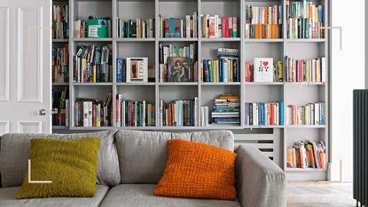 Well organised gray bookshelf with a gray sofa with orange cushion in the foreground to show how to organize bookshelves 