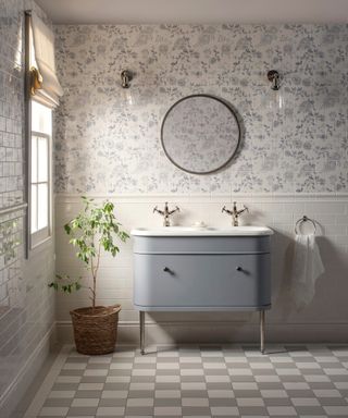 bathroom with lower wall tiled in white, chequerboard flooring, pale blue wallpaper and pale blue vanity unit