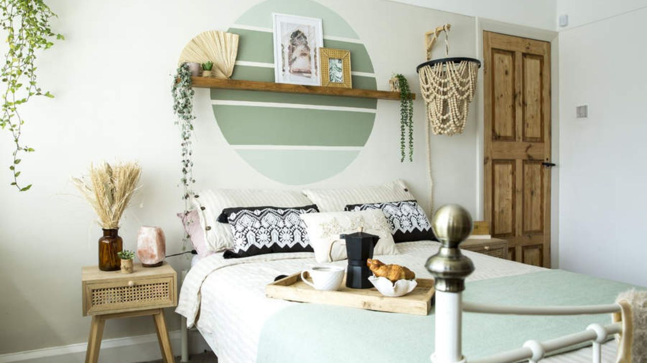 A green bedroom with a serene wall mural