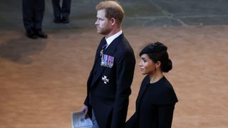 Prince Harry and Meghan, Duchess of Sussex walk as procession with the coffin of Britain's Queen Elizabeth arrives at Westminster Hall from Buckingham Palace for her lying in state on September 14, 2022 in London, United Kingdom.