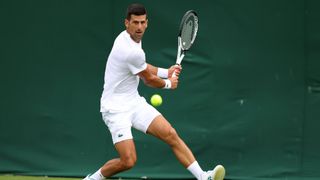 Novak Djokovic of Serbia plays a backhand during a practice session as Coach, Goran Ivanisevic, looks on ahead of The Championships - Wimbledon 2023 at All England Lawn Tennis and Croquet Club on June 28, 2023 in London, England.