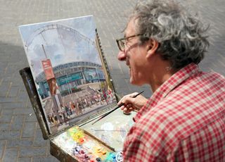 An artist paints a picture of Wembley Stadium ahead of the Euro 2020 final