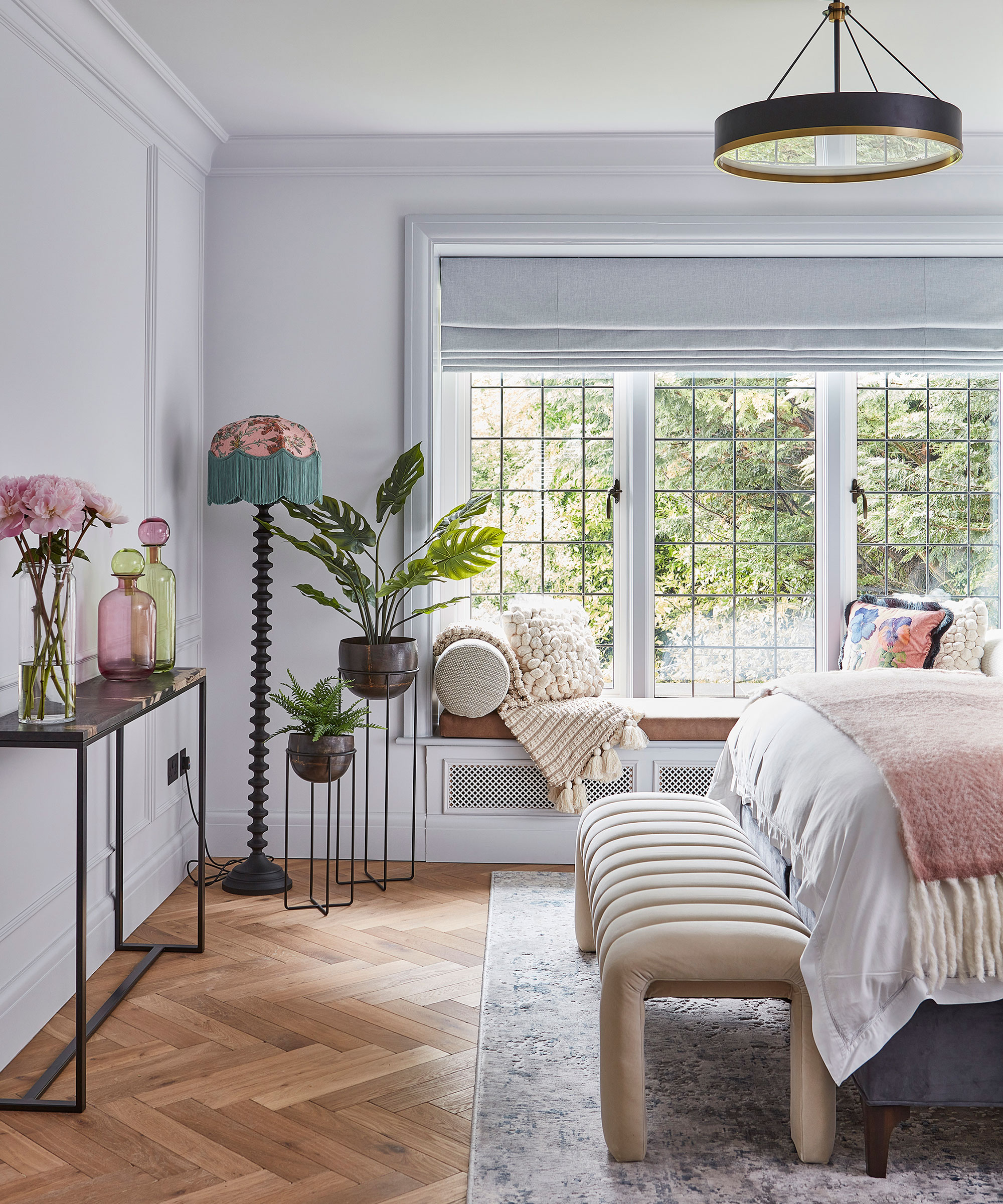 neutral airy master bedroom with window seat and herringbone wooden flooring