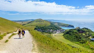 Walkers on the South West Coast Path overlooking Lulworth Cove in Dorset