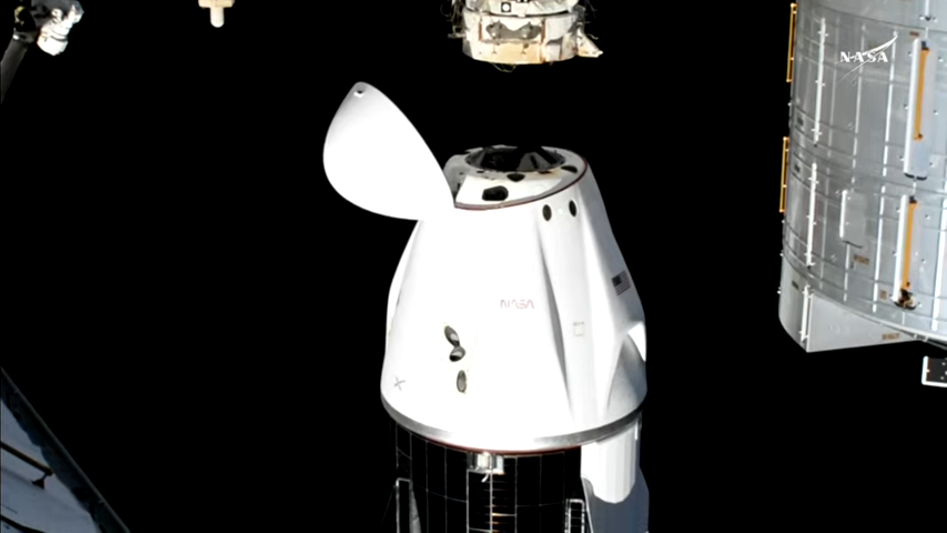 A white and black SpaceX Dragon Crew-9 spacecraft undocks from the International Space Station.