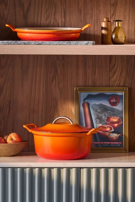 Le Creuset Modern Heritage Round Dutch Oven on a wooden shelf, with a brasier on the shelf above. 