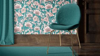 A bold, elegant hallway featuring teal and blush floral wallpaper with a dark wood skirting board. A teal velvet chair with brass legs and matching curtain adds modern sophistication.