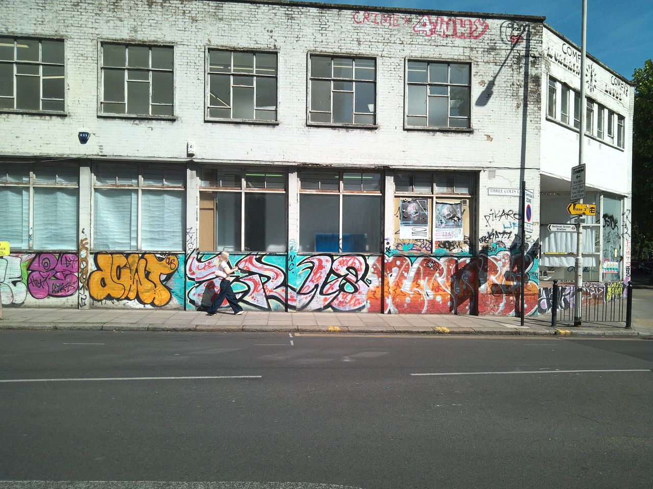 Sample image from Camp Snap CS-Pro digital compact camera showing woman walking in front of graffitied wall.