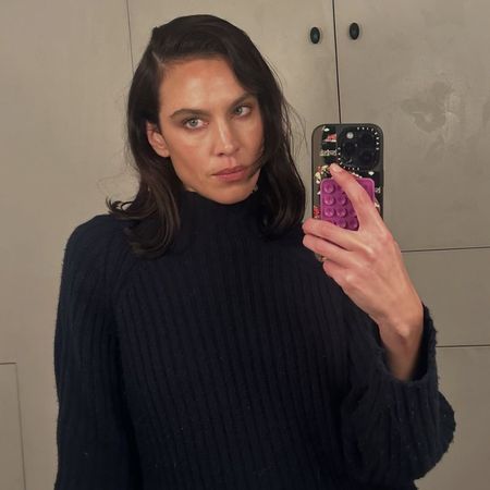 Alexa Chung wears a navy high-neck knit.