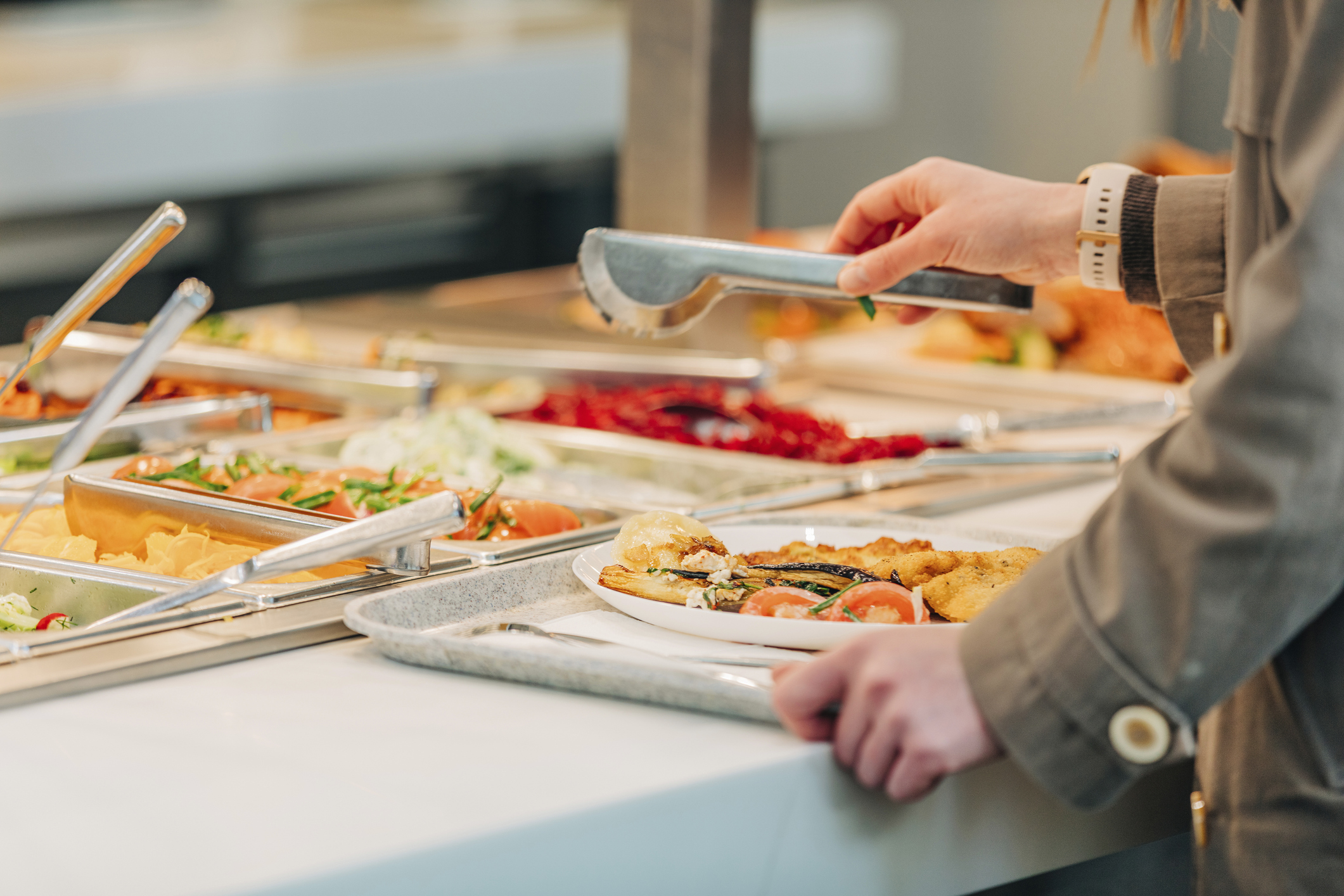 Woman puts food on her plate at the buffet