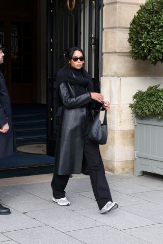 Laura Harrier wears an all-black outfit with sneakers in Paris.