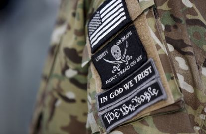 Patches on the sleeve of a militia man's jacket.