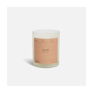 scented candle in glass container and orange label