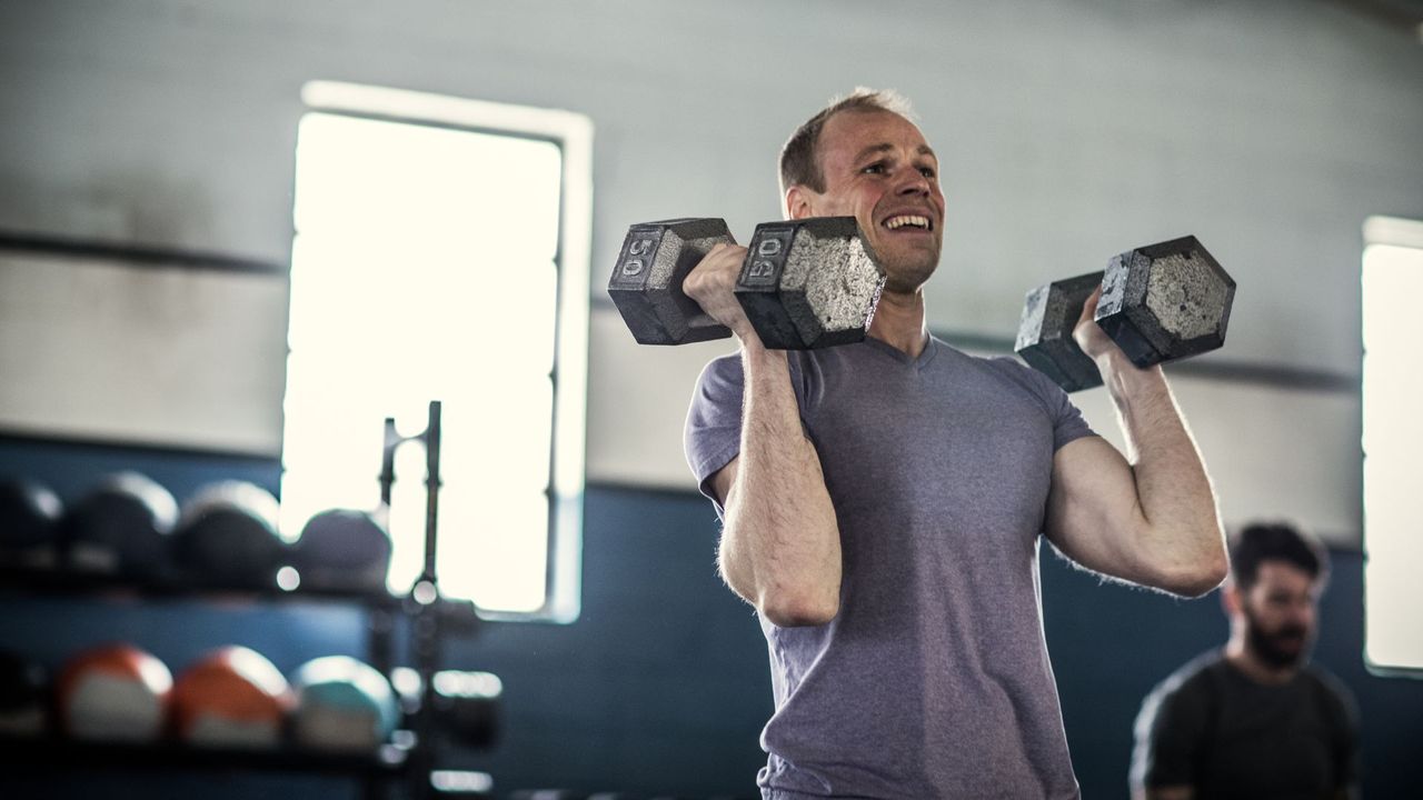 Man performing dumbbell shoulder press