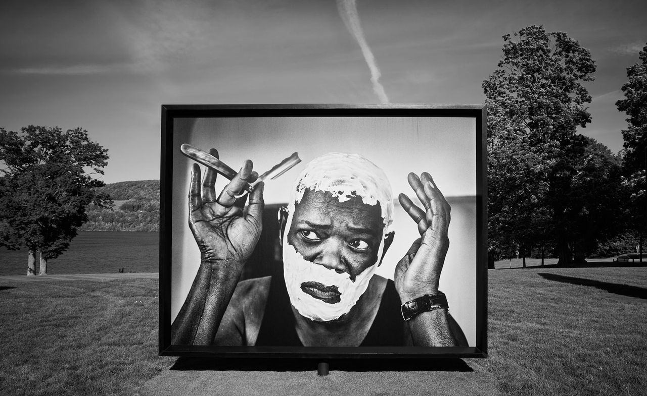 Installation view of &#039;Marc Hom: Re-Framed&#039; at Fenimore Art Museum, Cooperstown, showing black and white portrait of man shaving, on grass